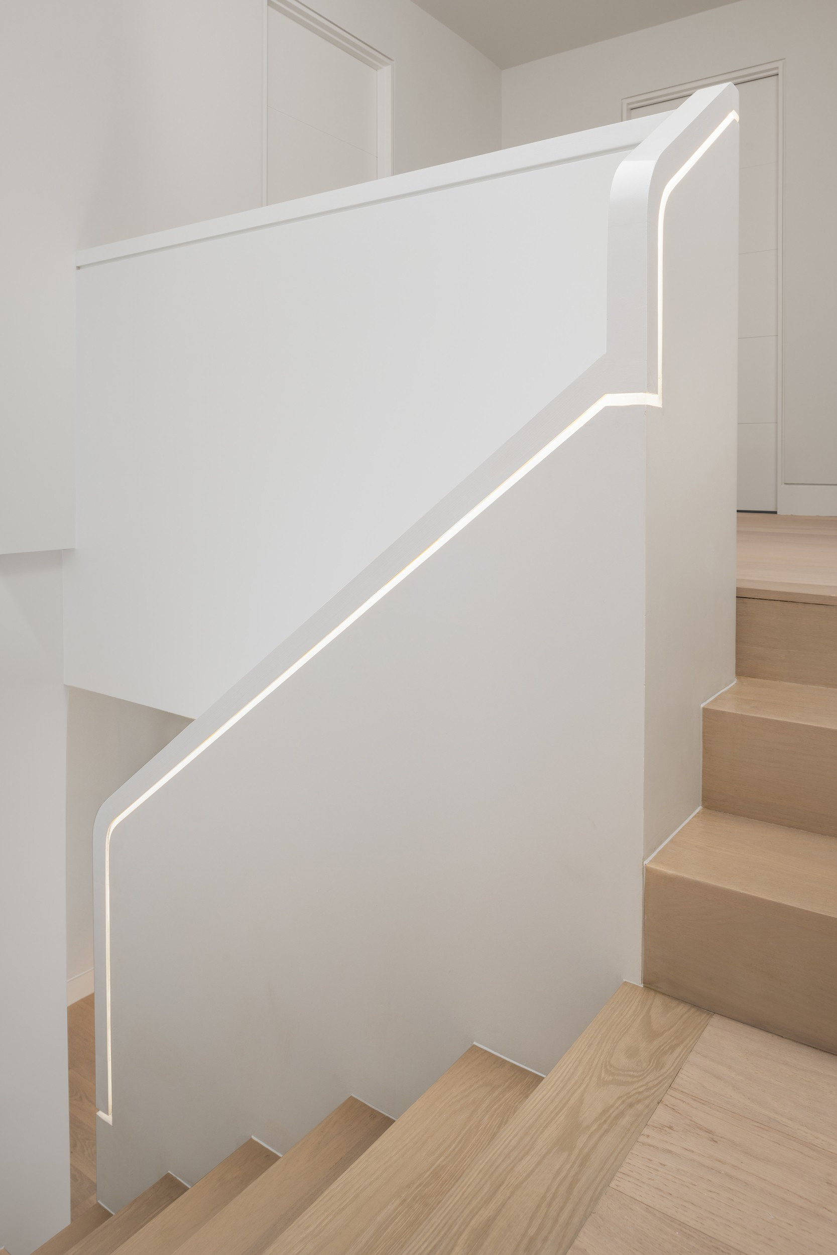 Curved, lit handrail — The Open House, Moore Park, Toronto — interior design by RZ Interiors