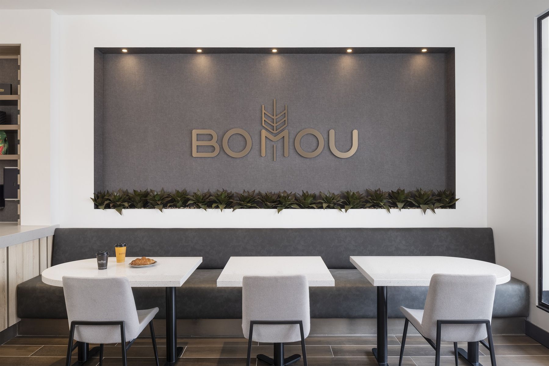 Seating under the brand wall — Bomou on Bayview, East York, Toronto — interior design by RZ Interiors